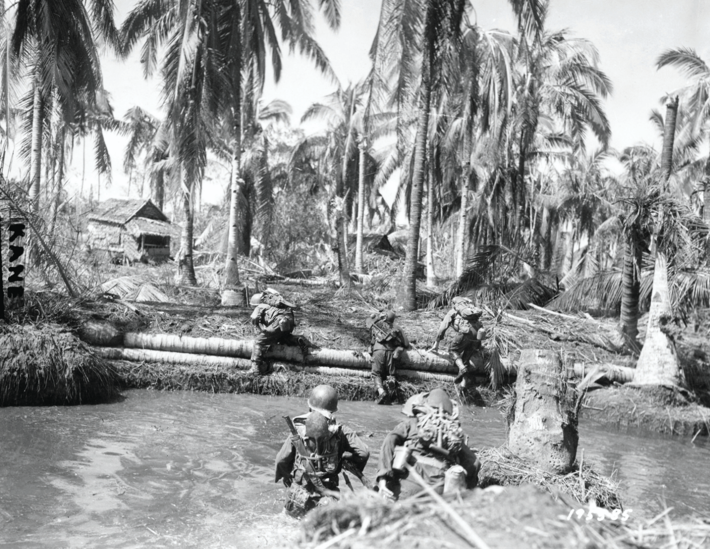 Water tank trap, one of many futile attempts made by retreating Japanese on Leyte Island to slow American invasion, is crossed by members of1st Cavalry Division, October 1944 (U.S. Army Signal Corps)